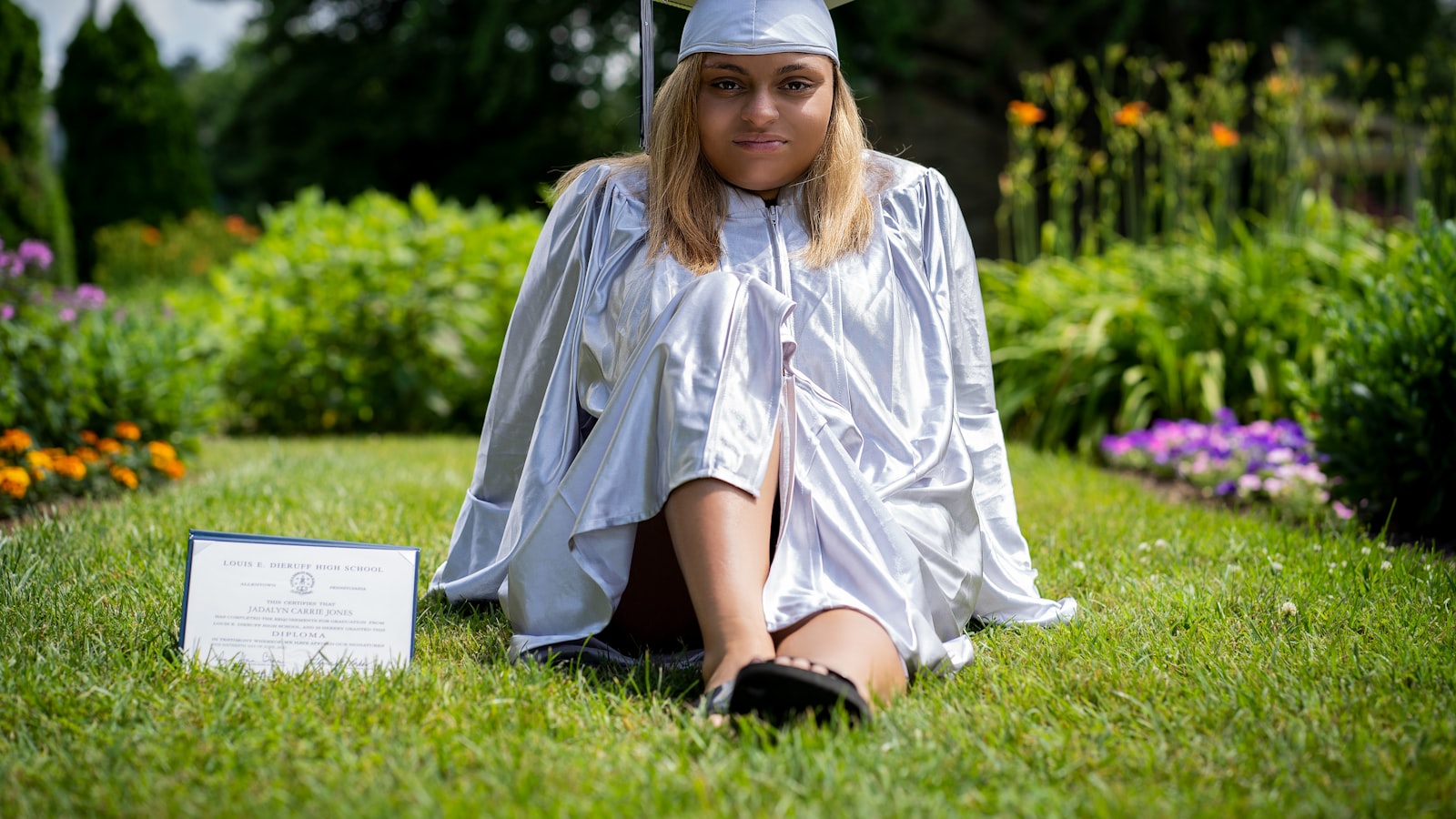 girl in blue dress shirt and black skirt sitting on green grass field