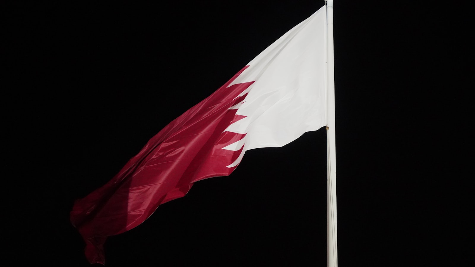 A red and white flag flying in the wind