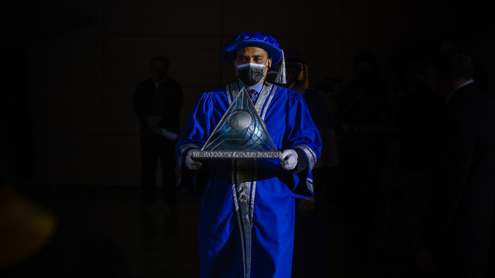 man in blue and white suit holding black microphone