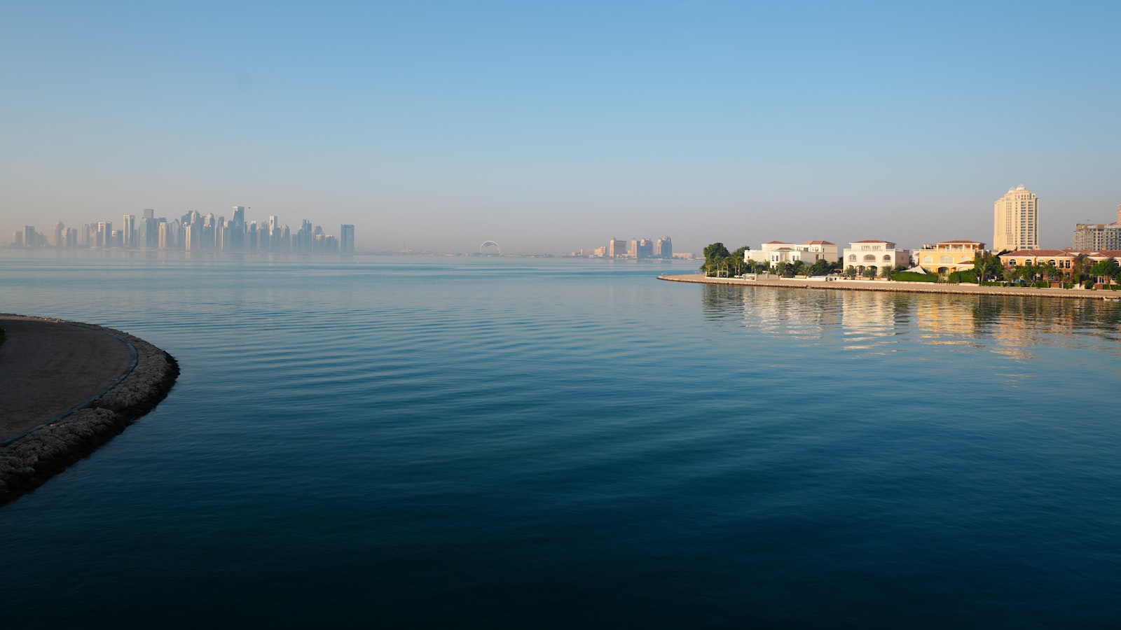 A body of water with a city in the background