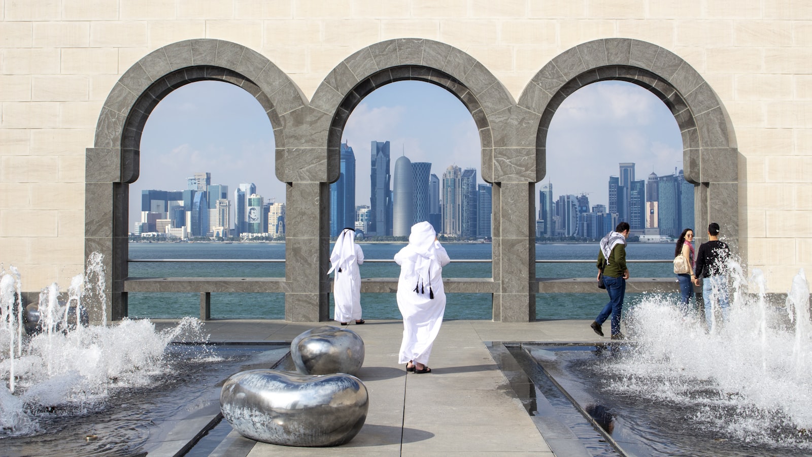 man in white robe standing near statue during daytime