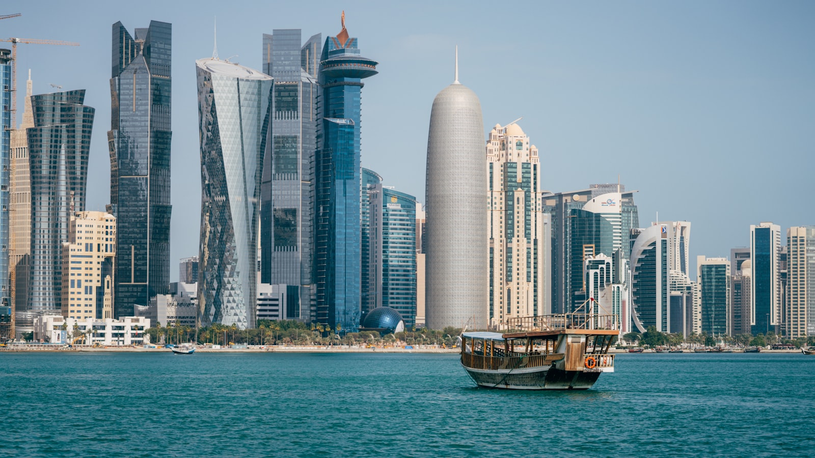 a boat in the middle of a body of water with a city in the background
