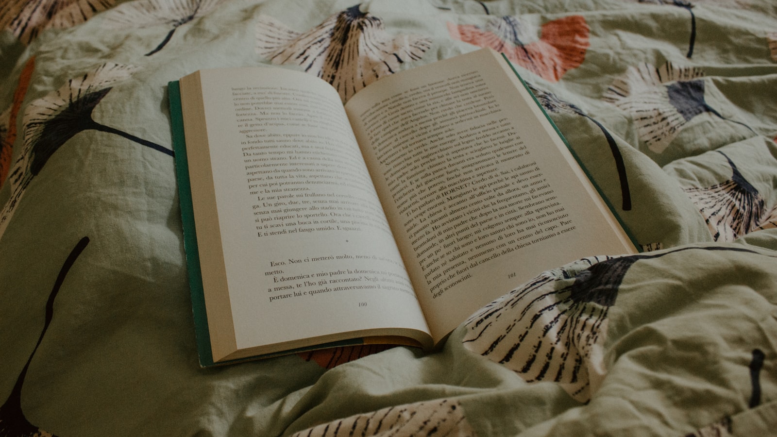 an open book sitting on top of a bed
