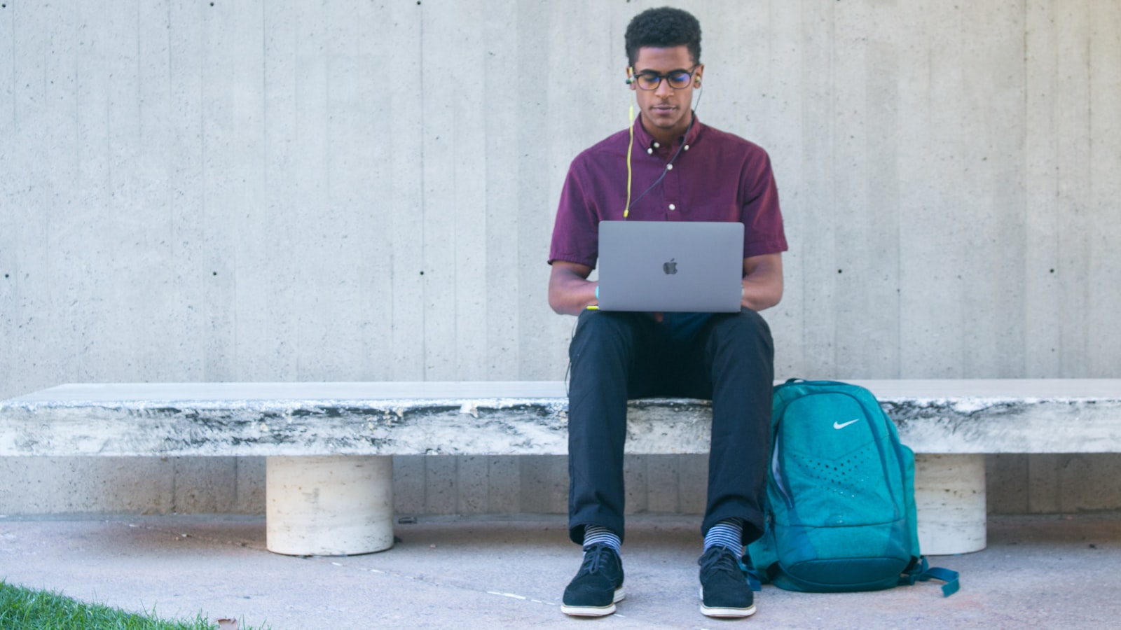 a man sitting on a bench with a laptop