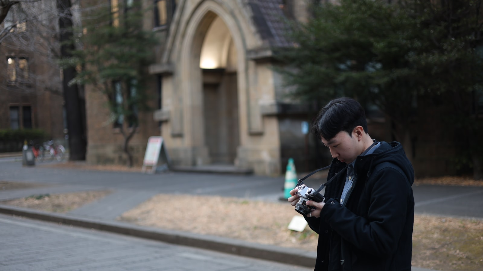 Man holding a camera in front of a building