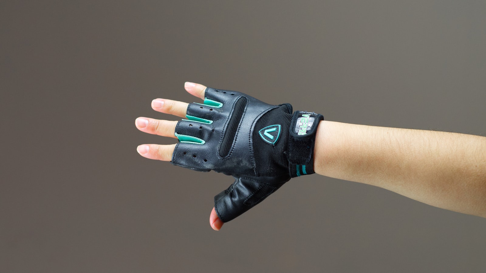 person wearing black and green leather fingerless gloves