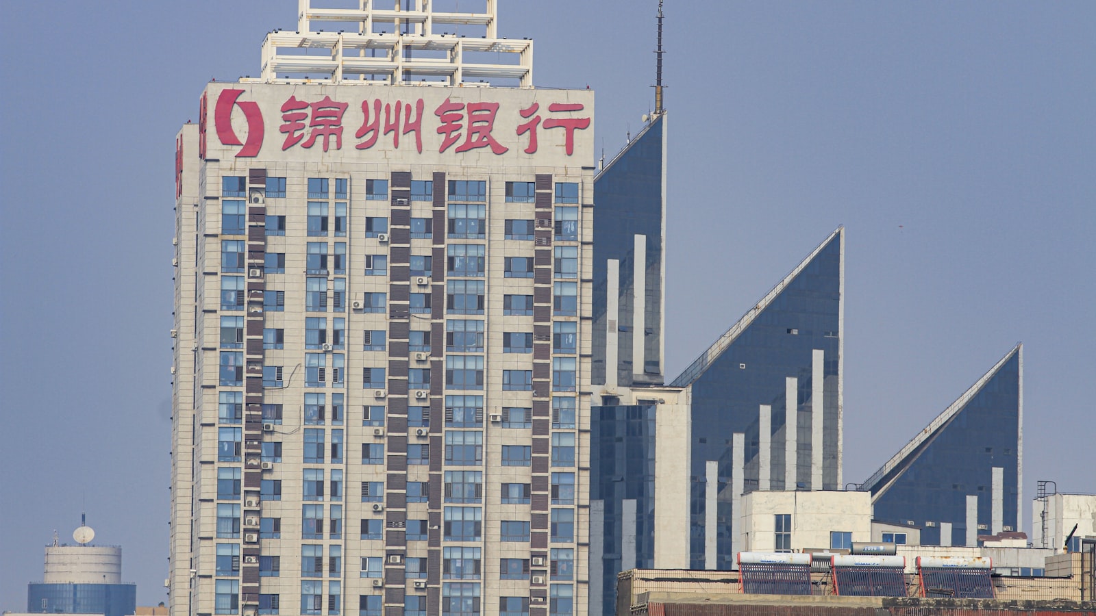 a tall building with a red and white sign in front of it