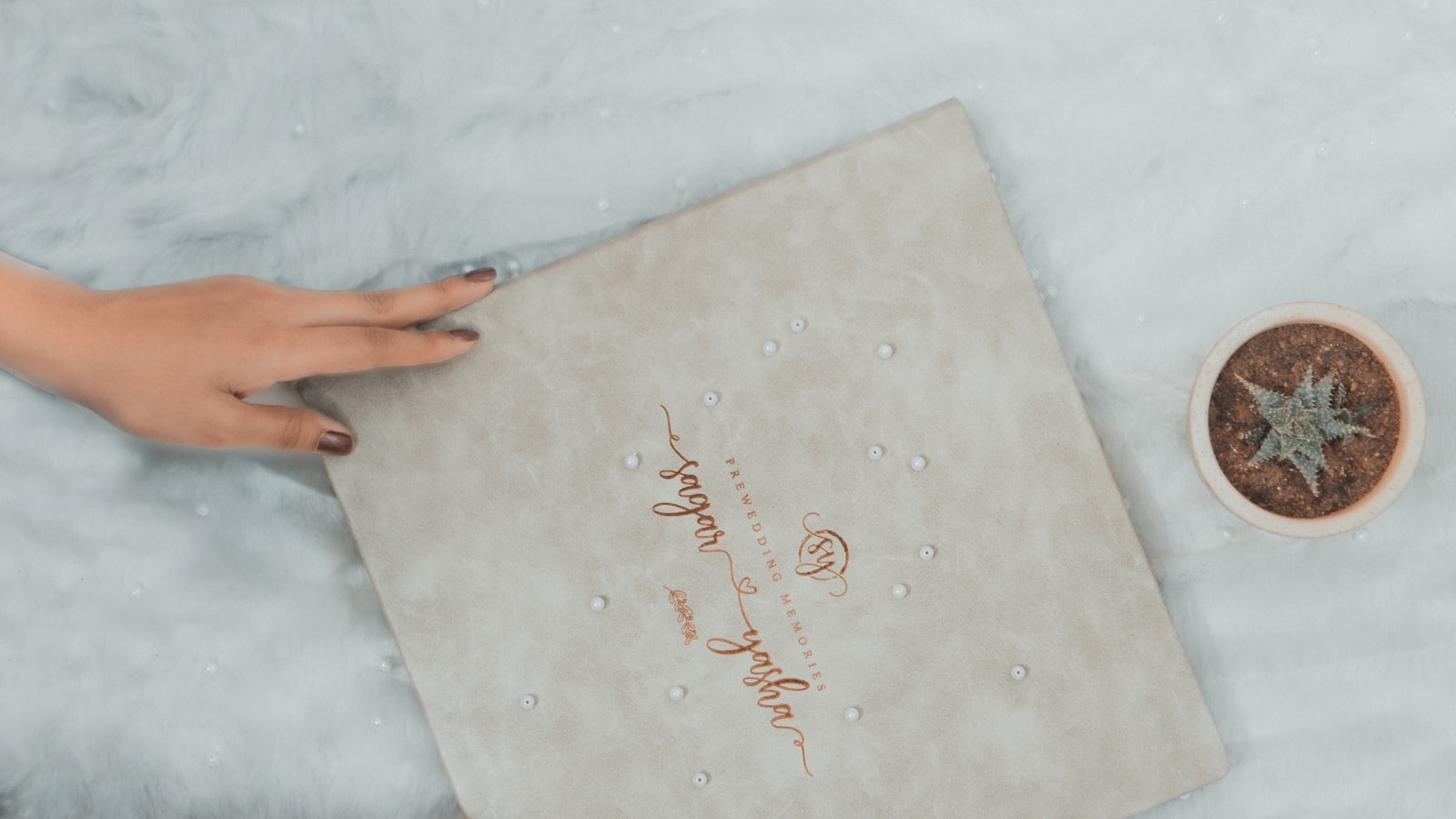 a woman's hands holding a wedding ring next to a box
