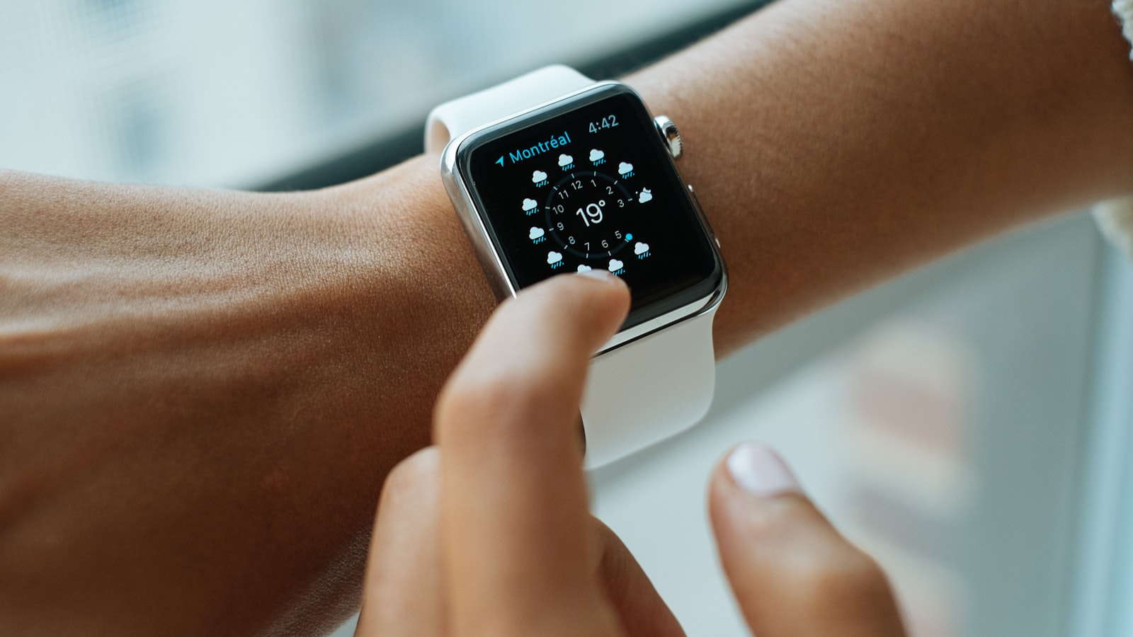 person wearing silver aluminium case Apple Watch with white Sports Band