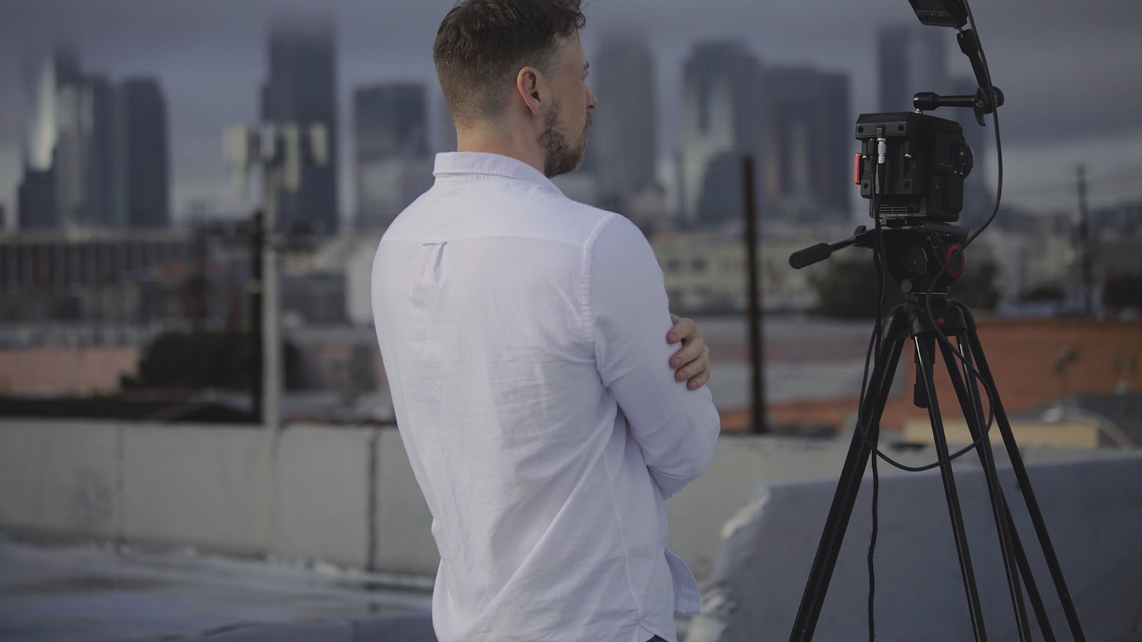 man in white long sleeve shirt standing in front of camera