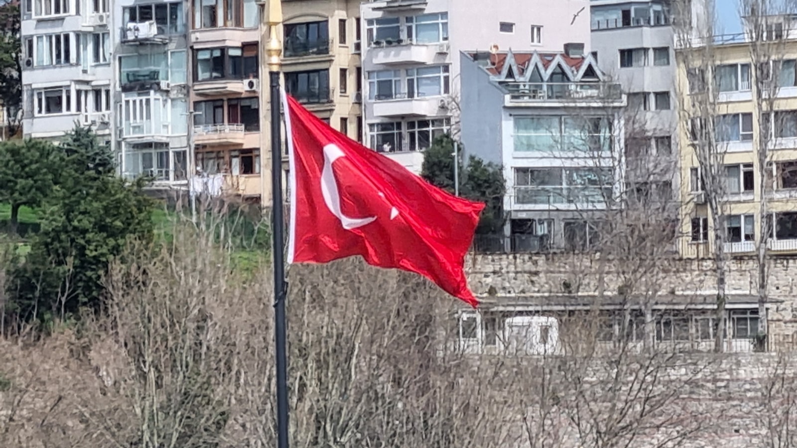 a turkish flag flying in front of some buildings