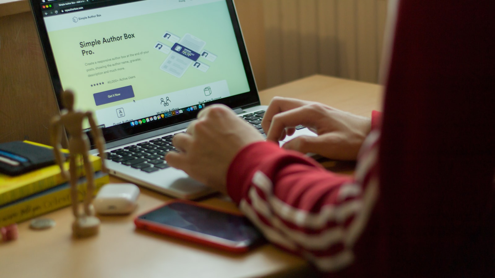 person using macbook pro on brown wooden table