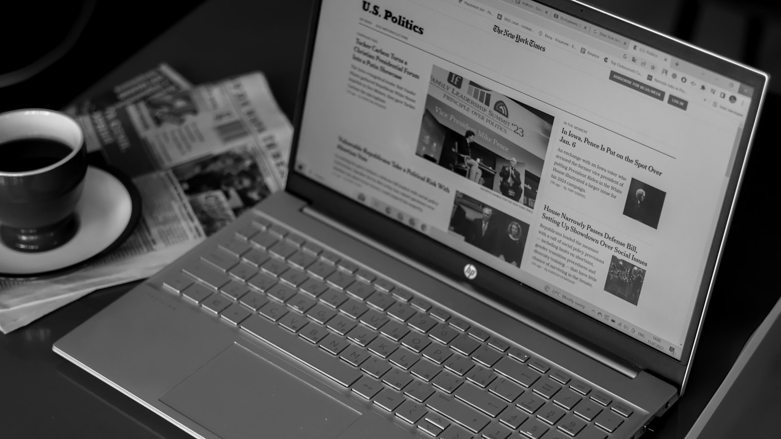 a laptop computer sitting on top of a desk next to a cup of coffee