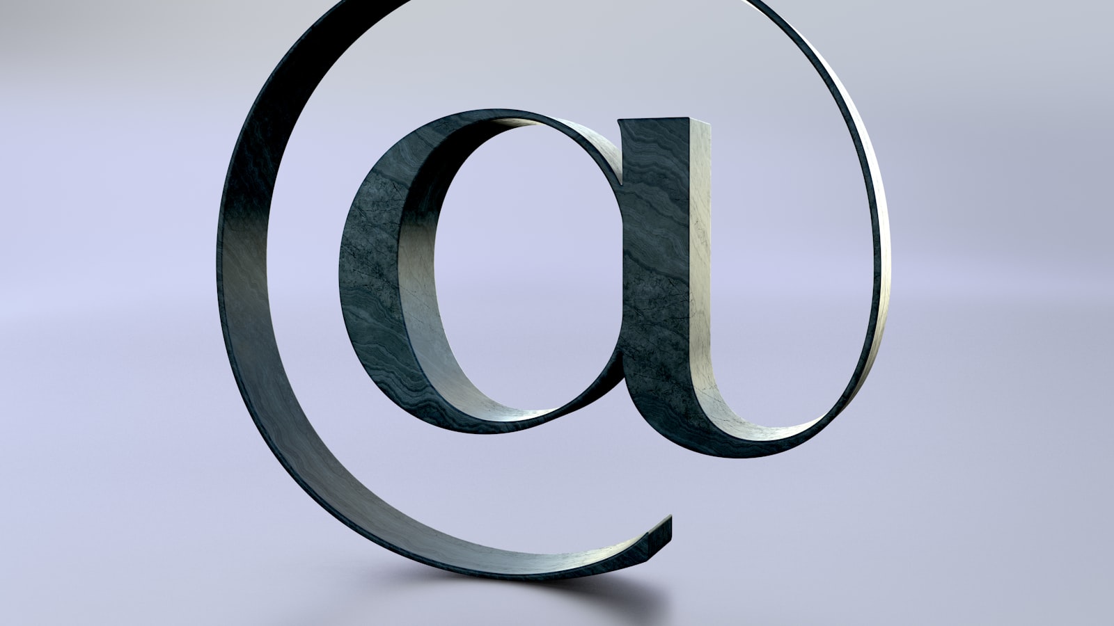 An at symbol is seen on a reflective surface.