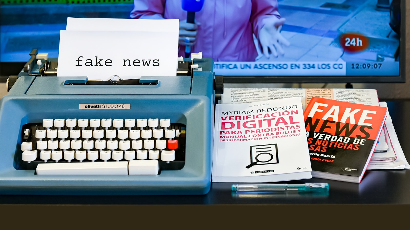 a blue typewriter sitting on top of a desk next to a tv