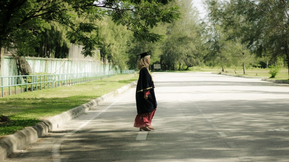 a person walking down a street with a hat on