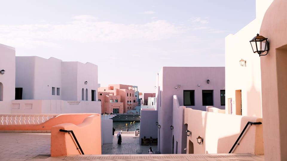 a person walking down a walkway between two buildings