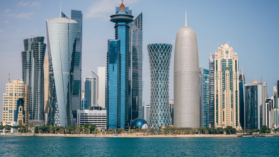 a group of tall buildings sitting next to a body of water