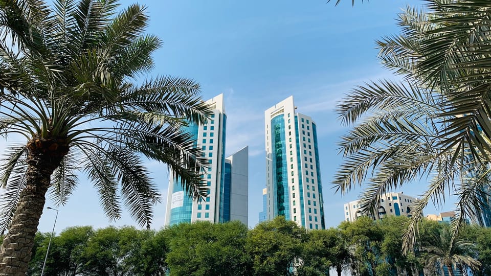 green palm trees near white high rise building during daytime