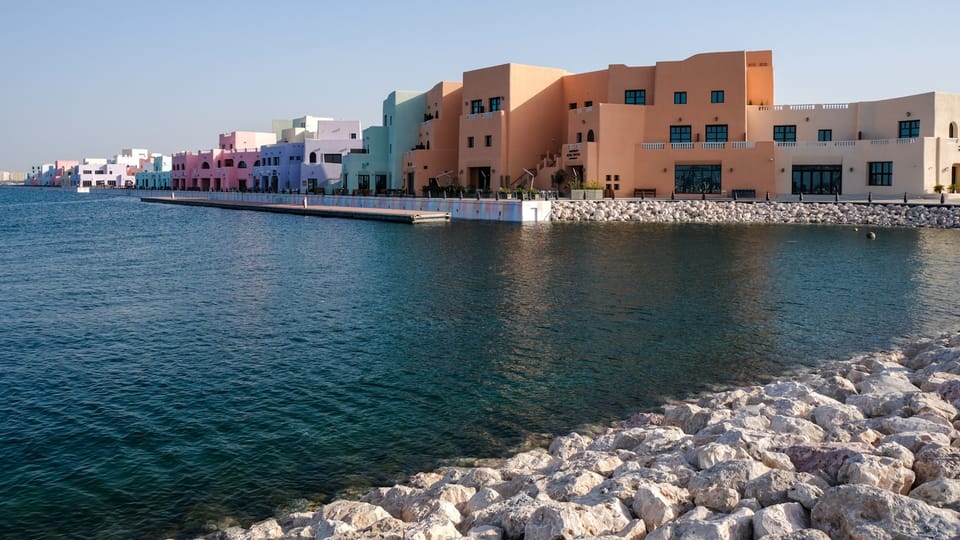 a body of water next to a row of buildings