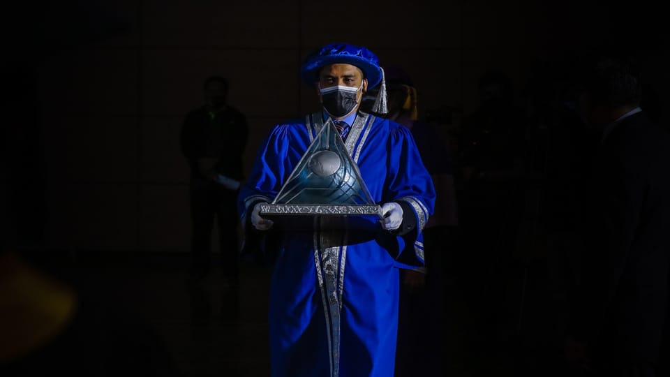 man in blue and white suit holding black microphone