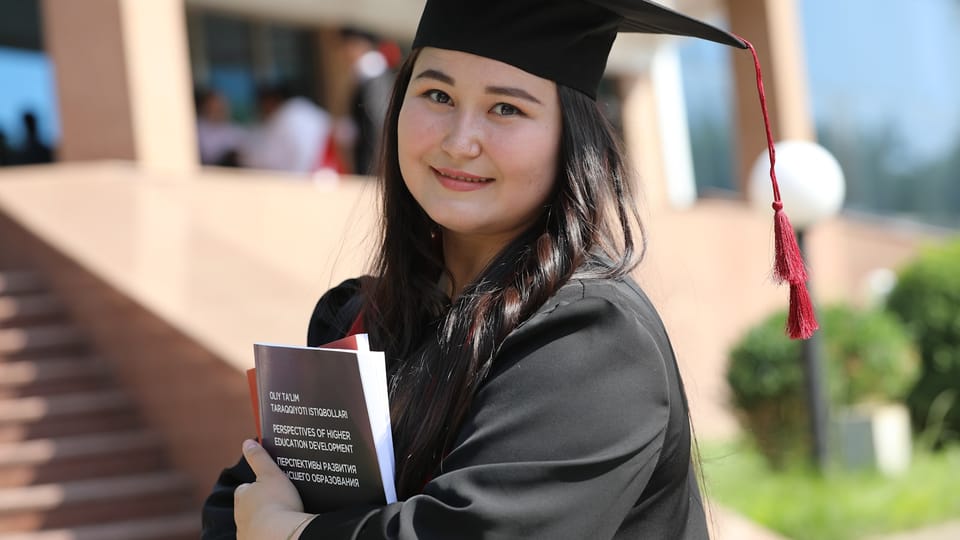 a woman in a graduation gown holding a book
