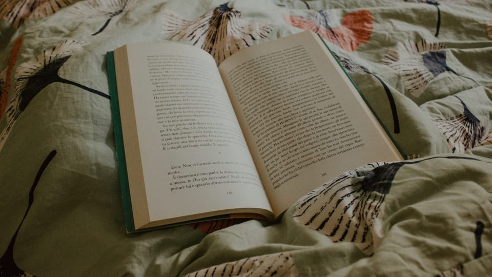 an open book sitting on top of a bed