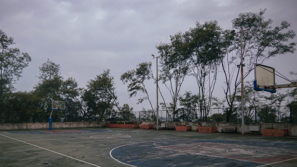 A basketball court with a basketball hoop in the middle of it