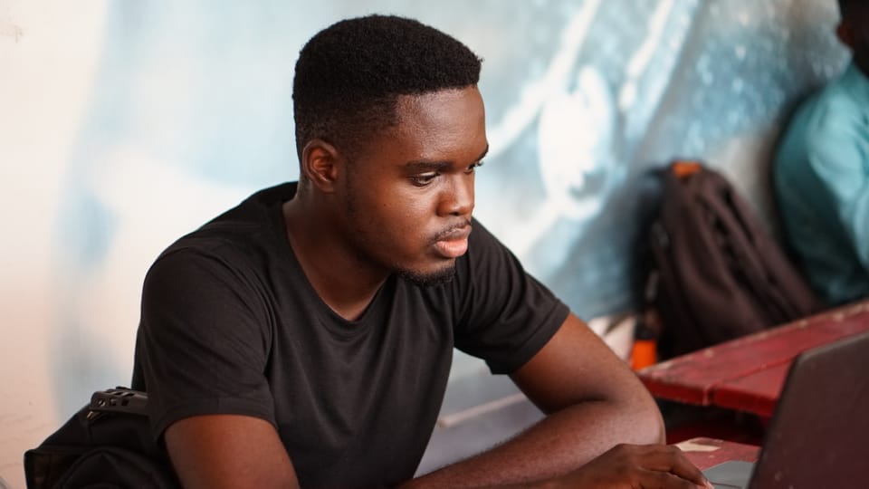 man in gray crew neck t-shirt using laptop computer