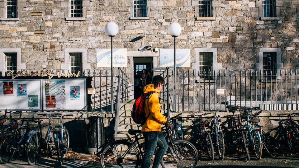 man in yellow jacket riding bicycle