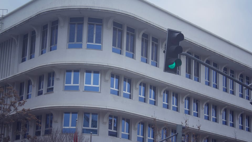 a traffic light sitting in front of a tall building