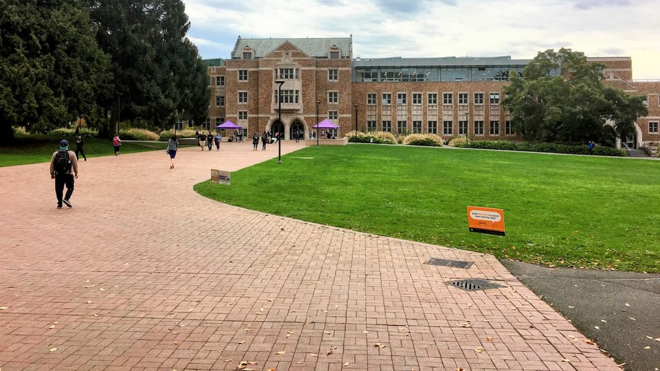 a group of people walking across a lush green field