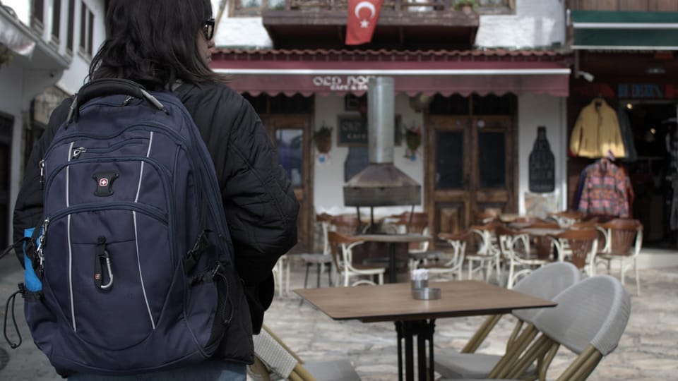 a person with a backpack is standing in front of a building