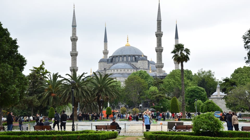 a group of people sitting on a bench in front of a building