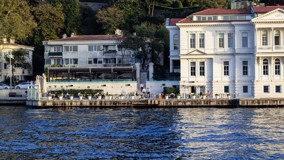 a large white building sitting next to a body of water