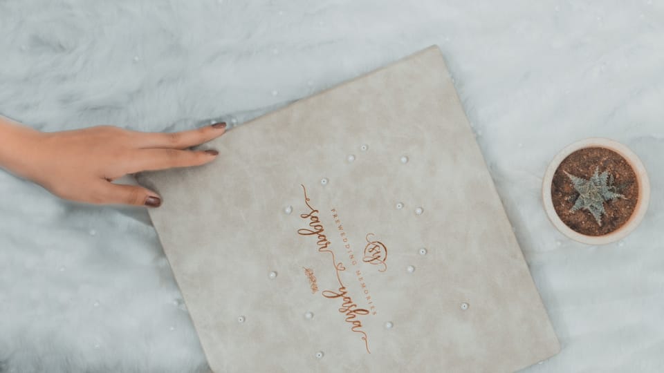 a woman's hands holding a wedding ring next to a box
