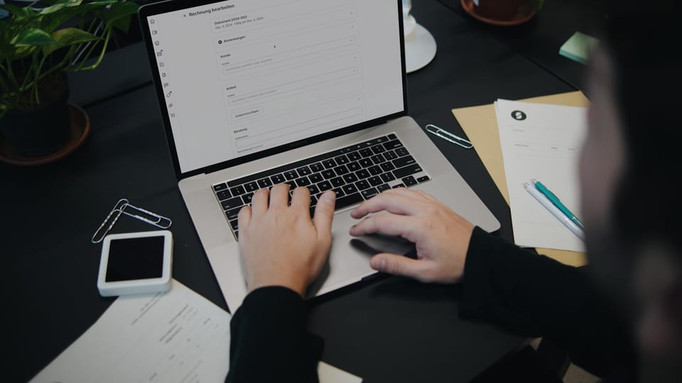 A person sitting at a desk using a laptop computer