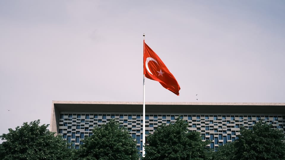 a turkish flag flying in front of a building