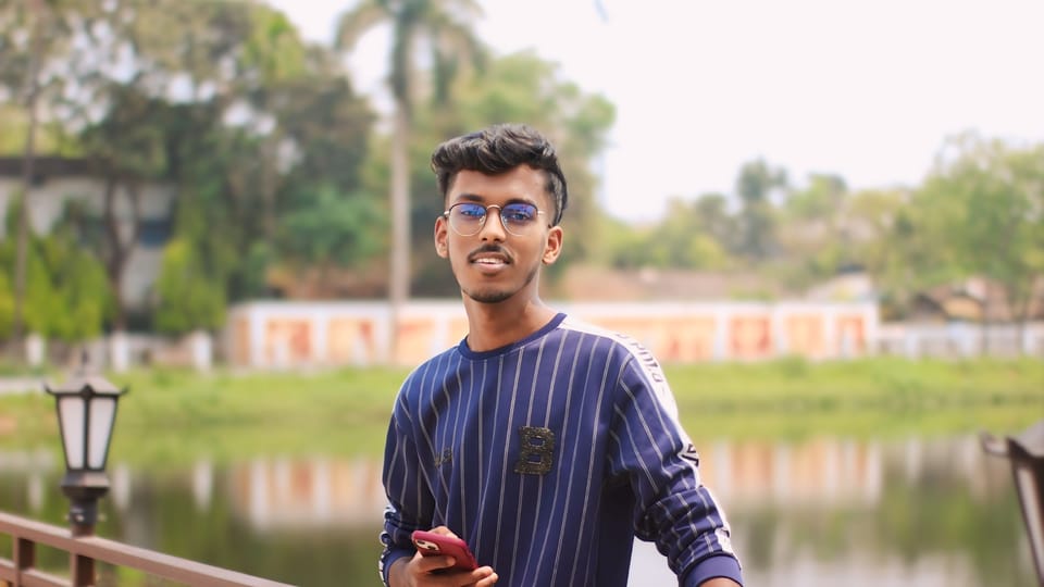 A man standing on a bridge holding a cell phone