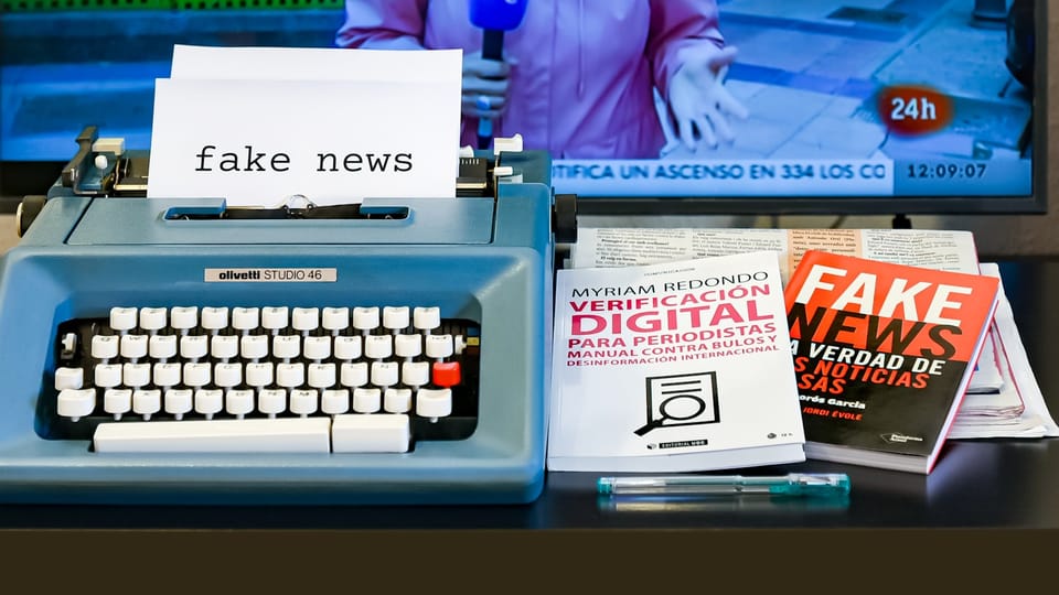 a blue typewriter sitting on top of a desk next to a tv