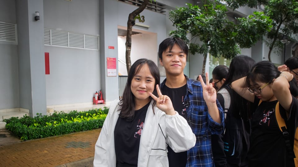 Two young people pose for a picture outdoors.